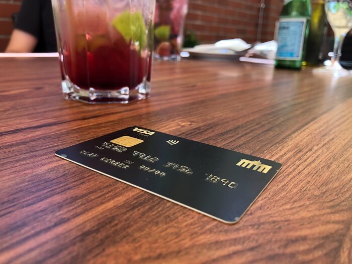 Deutschland-Kreditkarte Gold mit Cocktail im Restaurant